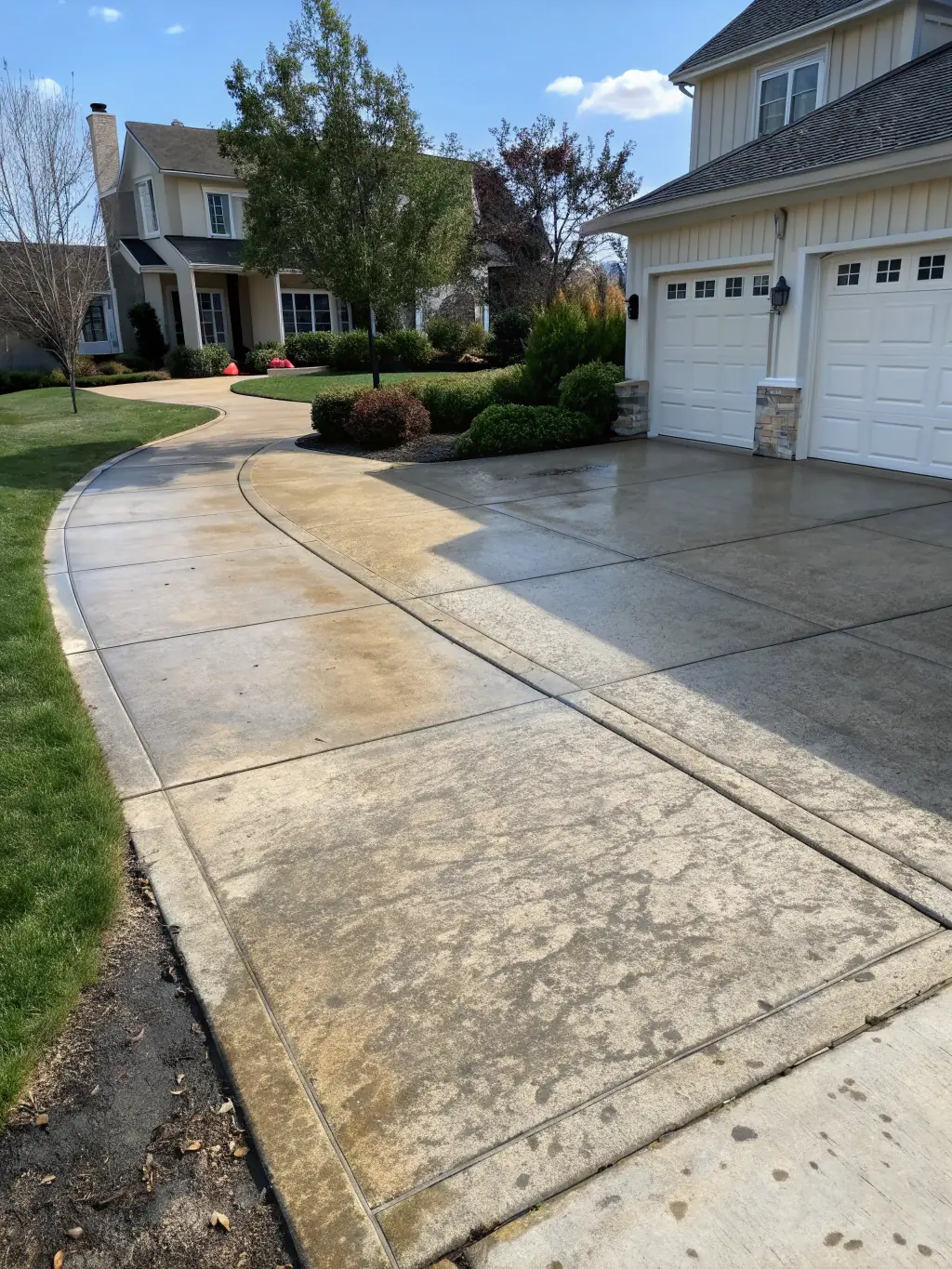 A driveway and patio in Jacksonville, Florida, before and after a soft wash cleaning, demonstrating the removal of stains and grime.